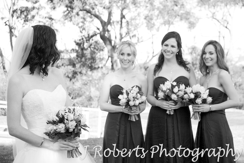 B&W bride looking at her bridesmaids - wedding photography sydney